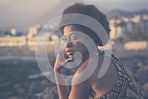 Side portrait of beautiful afro ethnic hair black model looking on camera serious and glamour. Outdoor african female people with