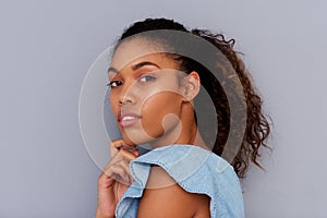 Side portrait of beautiful young african american woman against gray wall