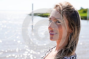 Side portrait blonde woman on summer beach in people vacation and leisure holidays concept