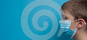 Side portrait of child boy wearing a medical mask.