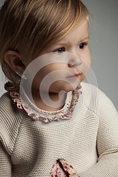 Side portrait of a cute little girl wearing knitted dress
