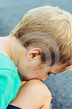 Side portrait handsome cute serious sad blond boy in bad mood look down. Artistic emotions. Problem or happy childhood