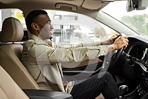 Side portrait of happy african american man driving car