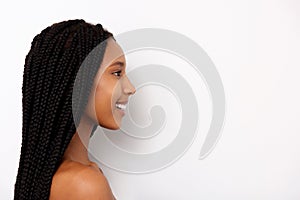 Side portrait of smiling african young woman with braids on white background