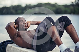 Side portrait of a young black man doing sit ups