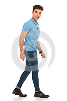 Side portrait of young man in blue shirt walking