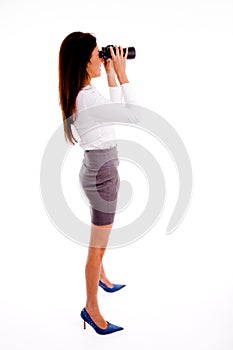 Side pose of executive looking through binocular