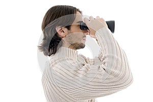 Side pose of young man watching through binocular