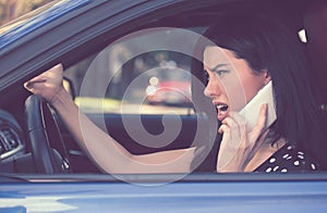 Side profile angry driver woman talking on mobile phone.