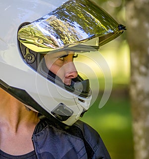 Side profile head and shoulders image of a young female motorcyclist wearing a full face helmet