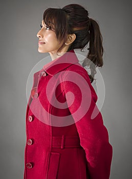 Side profile of an Indian young woman looking up with hands behind her back