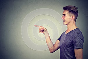 Side profile of a laughing young man pointing finger at someone