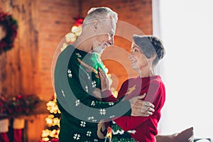 Side profile photo of old age sweethears hugs together wear funny christmas clothes stay home family atmosphere new year