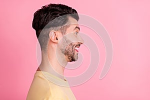 Side profile photo of optimistic satisfied man stylish haircut yellow t-shirt look empty space smiling isolated on pink