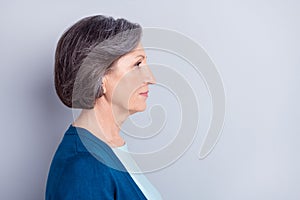 Side profile photo portrait of serious elder woman looking empty space isolated on grey color background