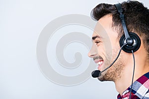 Side profile portrait of a cheerful guy call centre operator in
