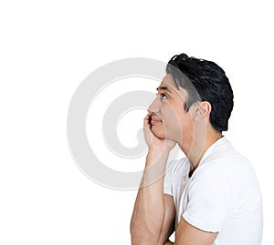 side profile portrait of smiling joyful happy young man looking upwards, chin on hands, isolated on white background