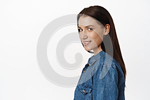 Side profile shot of adult attractive woman brunette, turn head at camera and smiling with confidence in her eyes