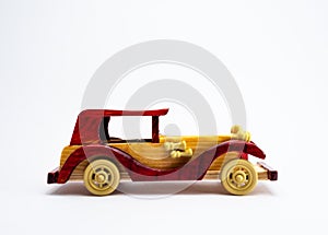 Side profile shot of a vintage toy car made with wood, shot against white background for royalty concept
