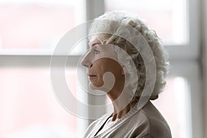 Side profile view face of elderly serious grey haired woman