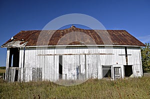 Side profile of a white abandoned barn