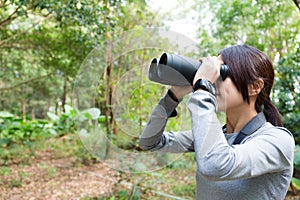 The side profile of Woman looking though binocular