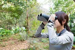 The side profile of Woman looking though binocular photo