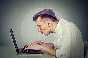 Side profile young man working on computer sitting at desk