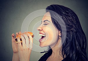 Side profile young woman eating a tasty burger