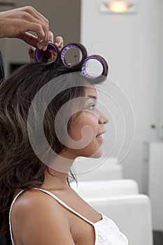 Side profile of young woman wearing curlers