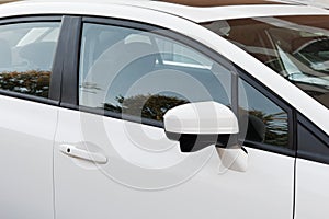 Side rear-view mirror on a white car