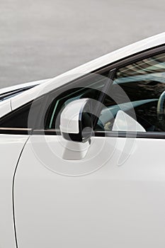 Side rear-view mirror on a white modern car