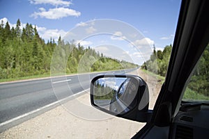 Side rearview mirror. The car is on the highway.Travel by car