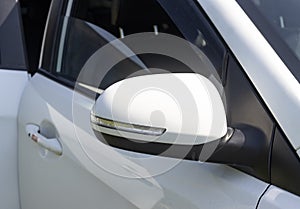 side rearview mirror of a white car with duplicate turning elements