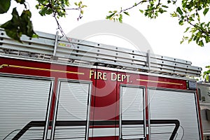 The side of a red fire truck with fire department written on the side.