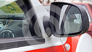 Side right black plastic rearview mirror on a white car. Exterior side view mirror on the passenger side, electrically adjustable