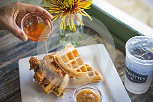 Side Shot of Pouring Syrup on Chicken and Waffles