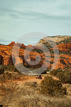 Side by side 4 wheeler driving on forest service road 525 in Coconino National Forest with red rocks mountains in background at