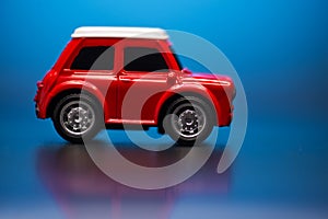 Side side; view of Red colored little toy model car on a blue background