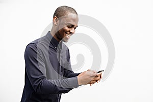 Side of smiling African American man using mobile phone by isolated white background