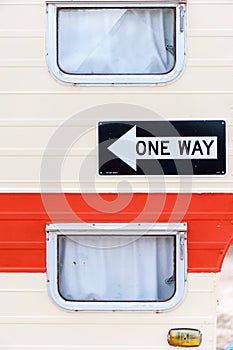 Side of a trailer or caravan / cabin with windows and one way sign visible