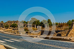 SIDE, TURKEY: Ancient ruins and a road in the city of Side on a sunny summer day.