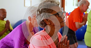 Side view of active mixed-race senior people performing yoga in fitness studio 4k