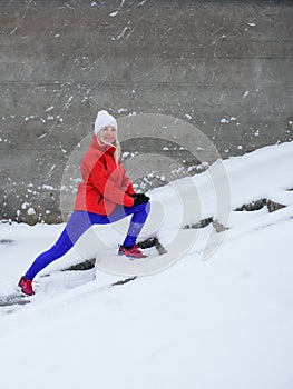 Side view of active senior woman outdoors in snowy winter, doing exercise.