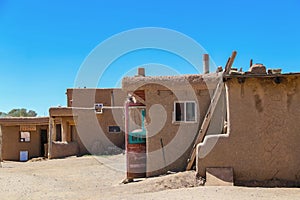 Side view of adobe mud buildings in a pueblo in the Southwestern USA, with shops with doors open for selling local crafts and
