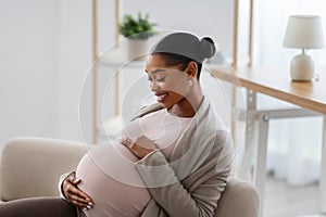 Side view of african american expecting woman touching her big belly