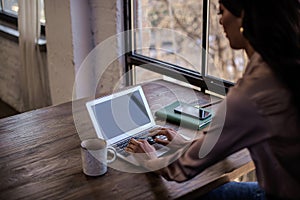 Side view of an african american woman using laptop at cafe