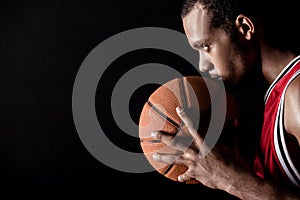 Side view of african sporty man holding basketball ball