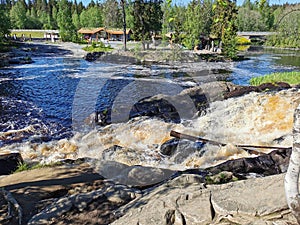 Side view of the Ahvenkoski waterfall on the Tokhmayoki River in Karelia on a clear summer morning photo