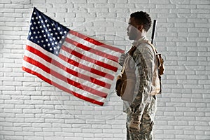 Side view of American soldier near national flag.